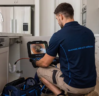 Plumber clearing a blocked toilet in a Haberfield bathroom